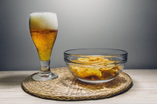 potato-chips-and-beer-glass-on-table-mat