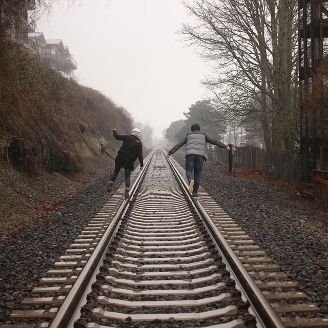 friends-balancing-on-railroads-on-autumn-day